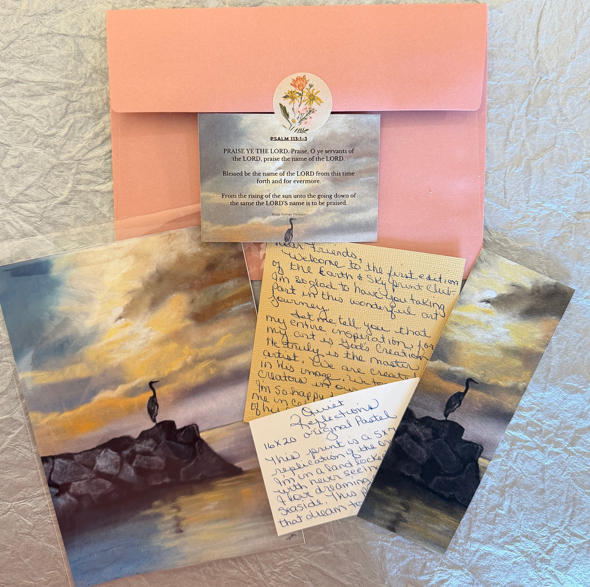Melanie’s first art-club mailing with heron artwork, handwritten notes, devotional card, bookmark, and peach envelope